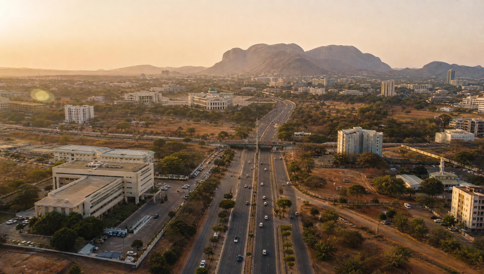 Aerial view of an Abuja estate layout and city skyline at golden hour
